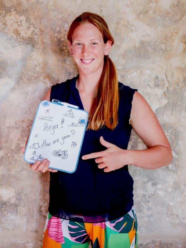 ginger teacher smiling with a board 